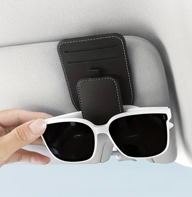 Black car sun visor eyeglass holder with sunglasses